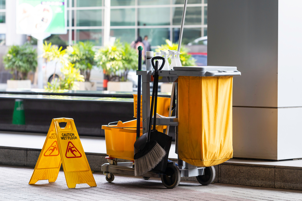 Janitorial and mop bucket on cleaning in process.